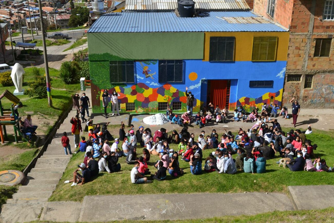 Familien sitzen auf der Wiese vor dem Haus der CES Waldorf