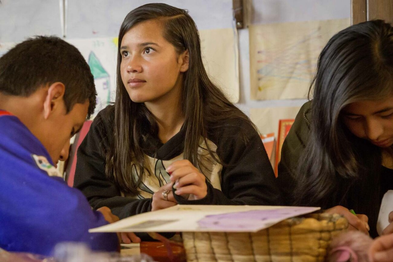 3 Jugendliche sitzen bei den Hausaufgaben